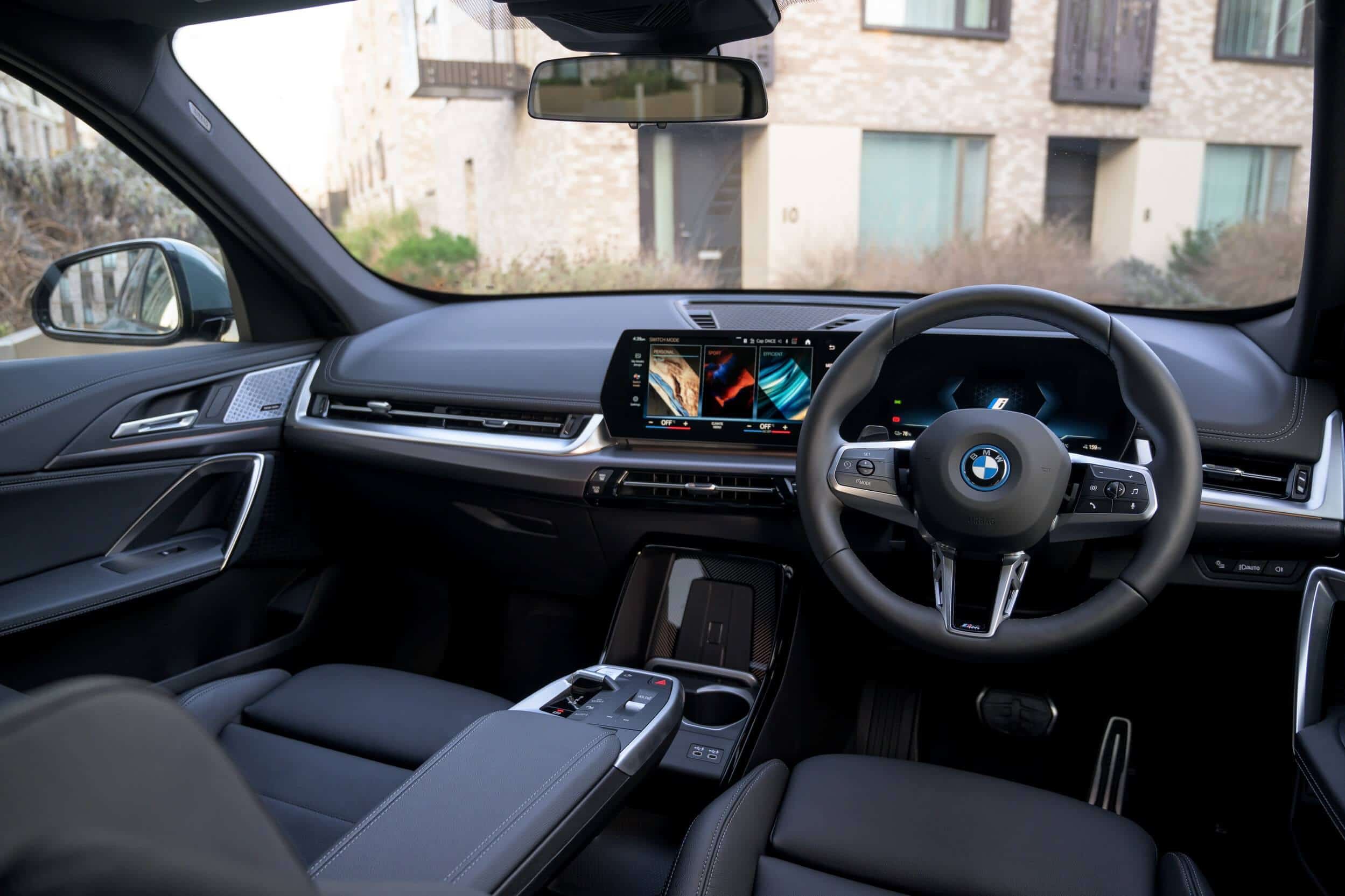 BMW iX1 rear three-quarter, comparing salary sacrifice against a personal lease