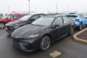 2025 Toyota Camry HEV in pearl white photographed in three-quarter view