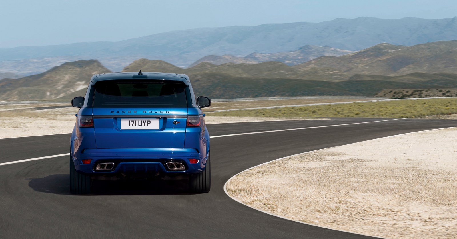 Range Rover Sport L494 facelift rear shot on a mountain road, showing twin exhausts and tailgate styling