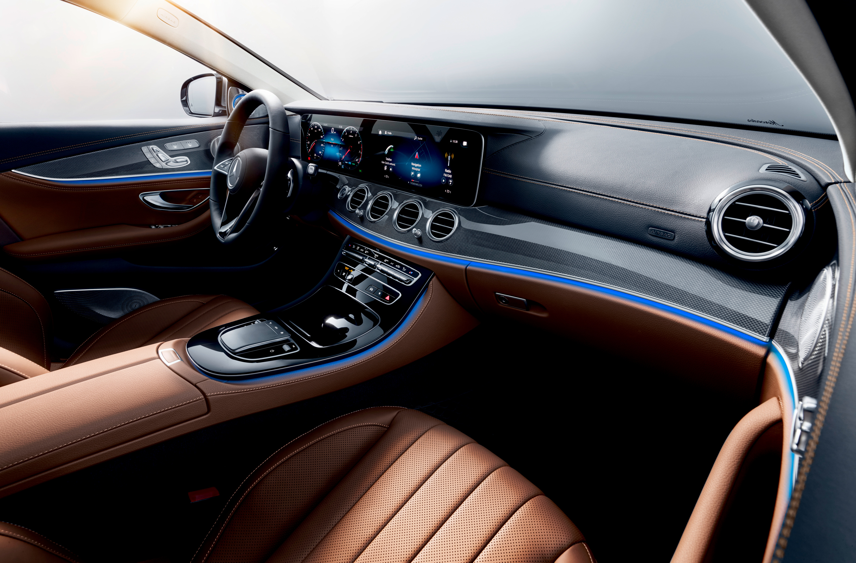 Mercedes E-Class W213 interior with twin-screen MBUX dashboard, ambient lighting and saddle-brown leather