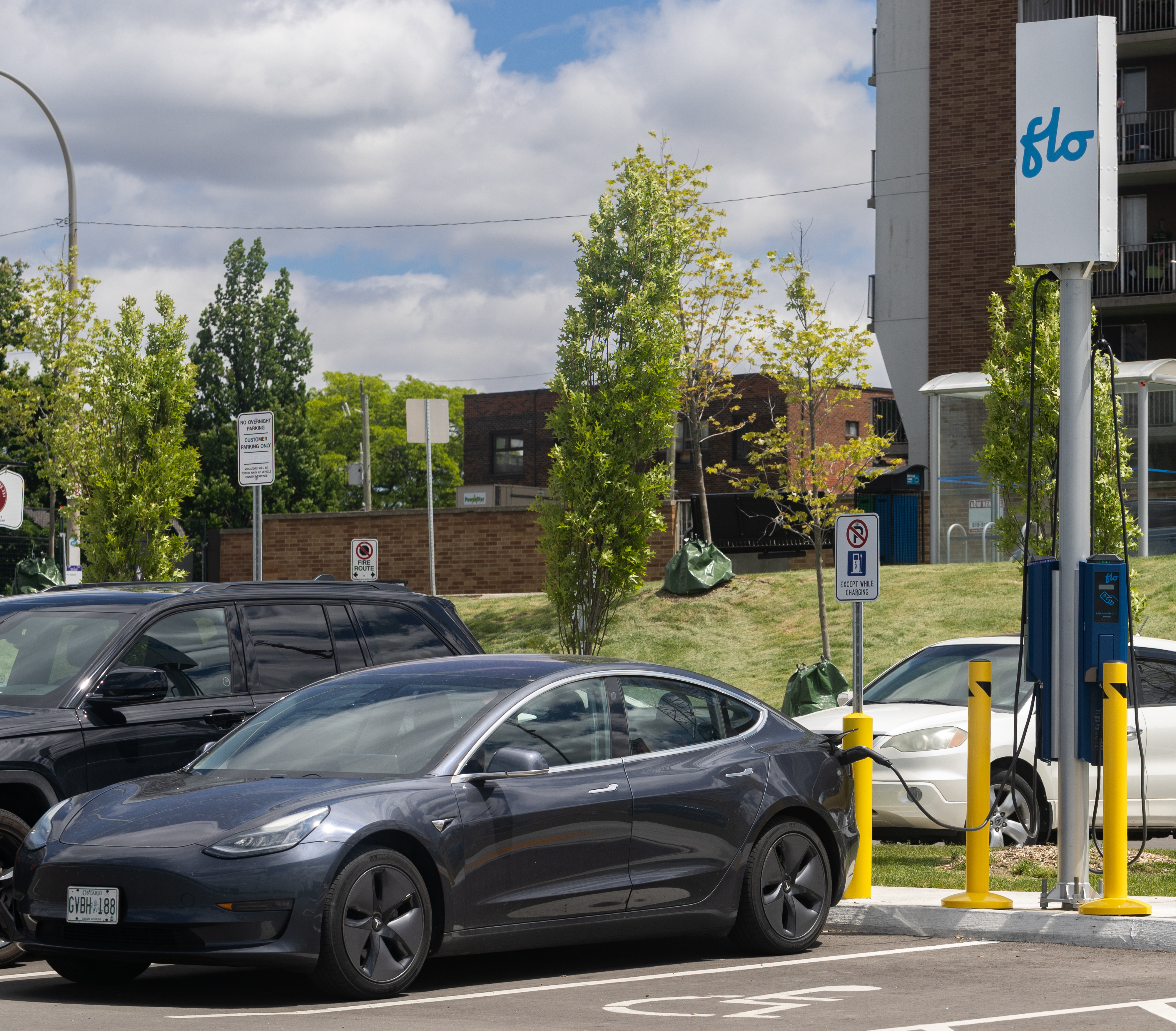 Tesla Model 3 charging at North American charger illustrating state EV rebates 2026