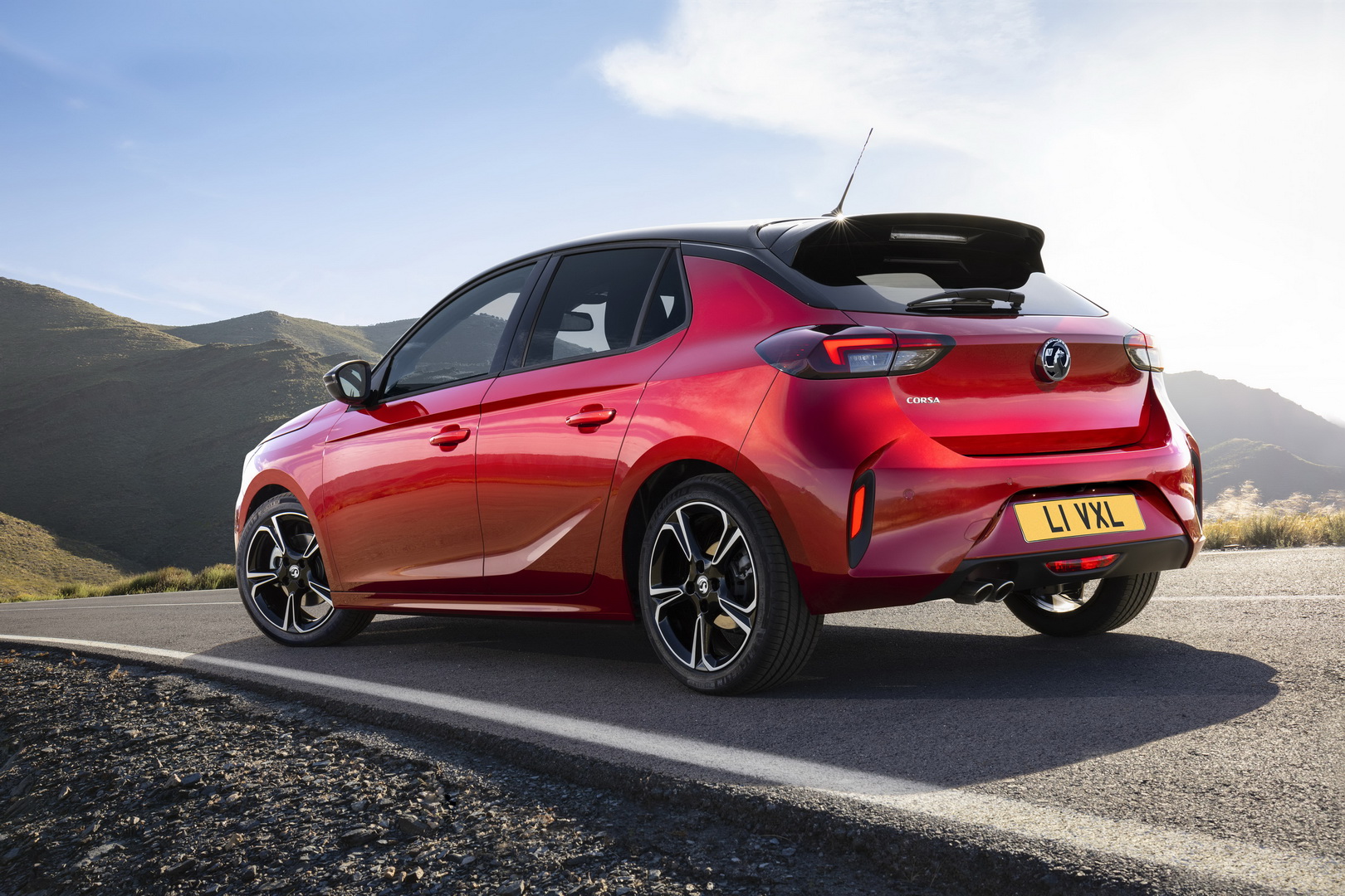 Rear three-quarter view of a red Vauxhall Corsa on a coastal road