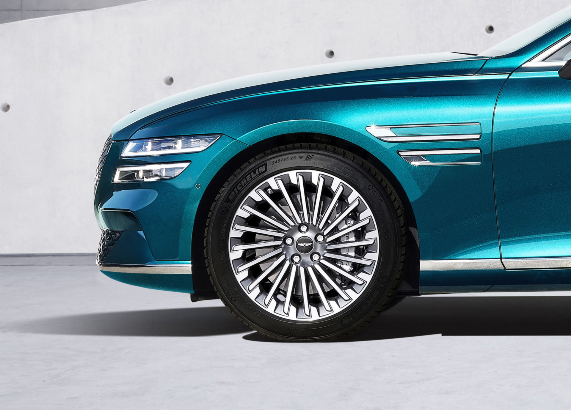 Genesis Electrified G80 front wheel and charge-port detail in teal