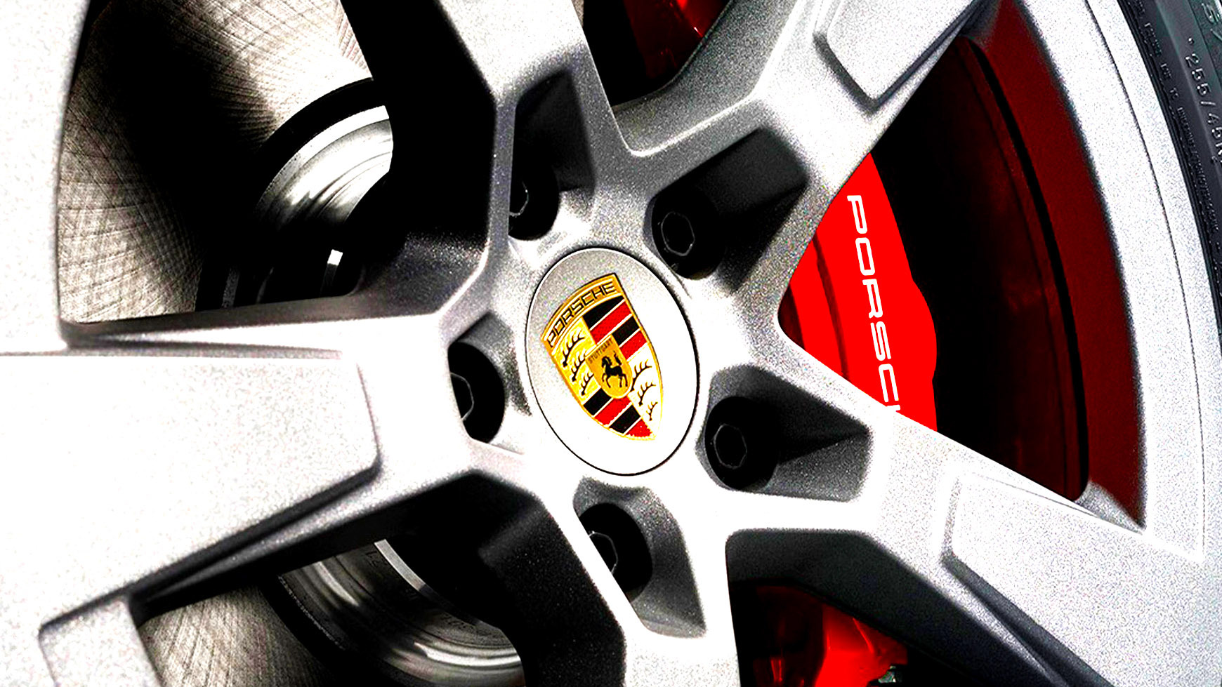 Close-up of a Porsche alloy wheel and performance tyre with manufacturer approved marking