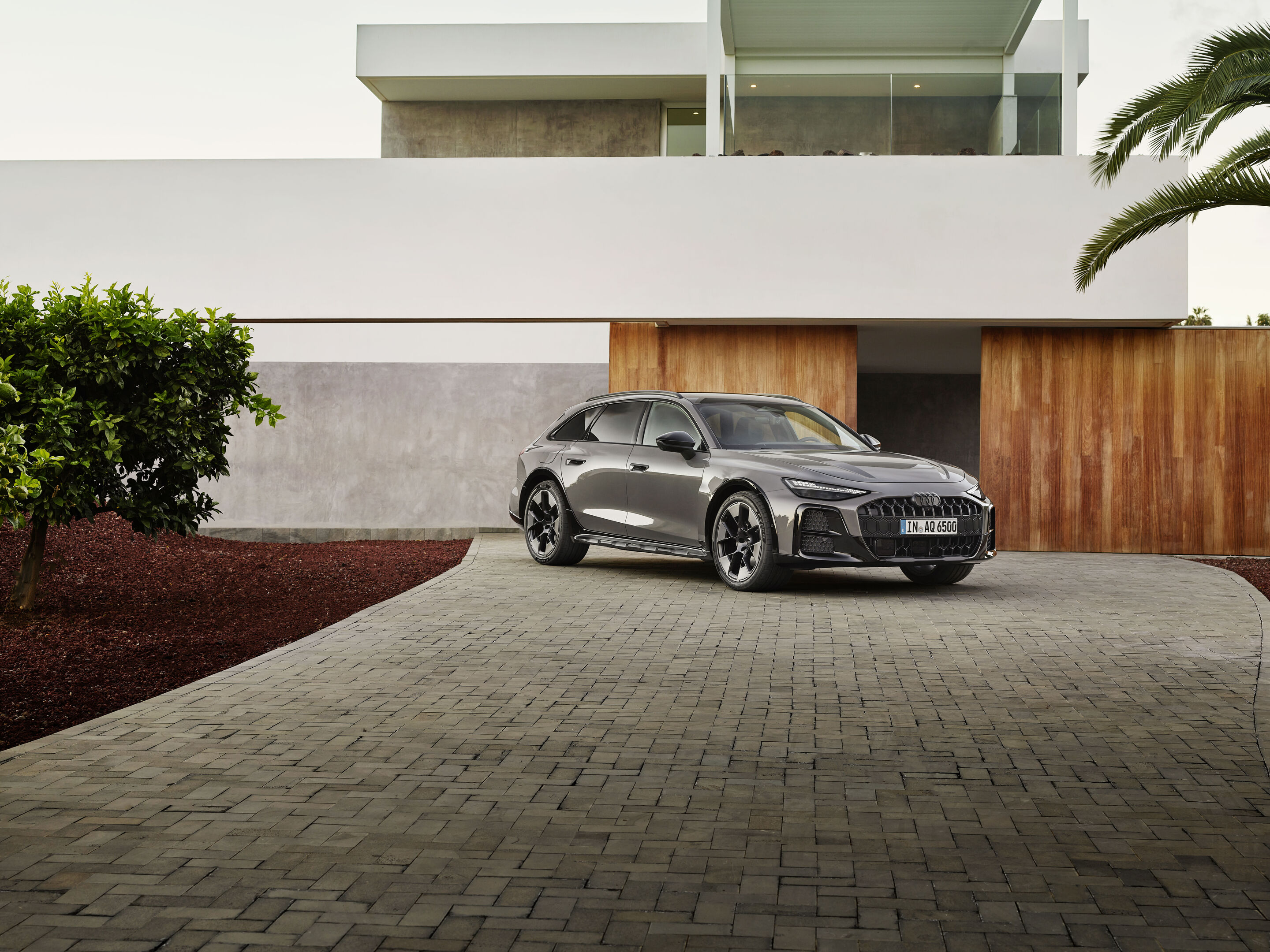Audi A6 Allroad 2026 front three-quarter on a driveway, showing the new front grille