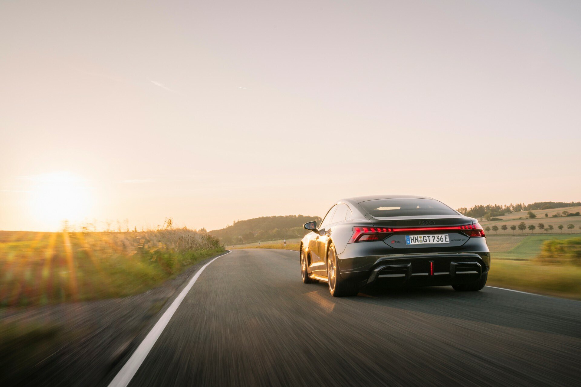 Audi e-tron GT driving at sunset, used EV value