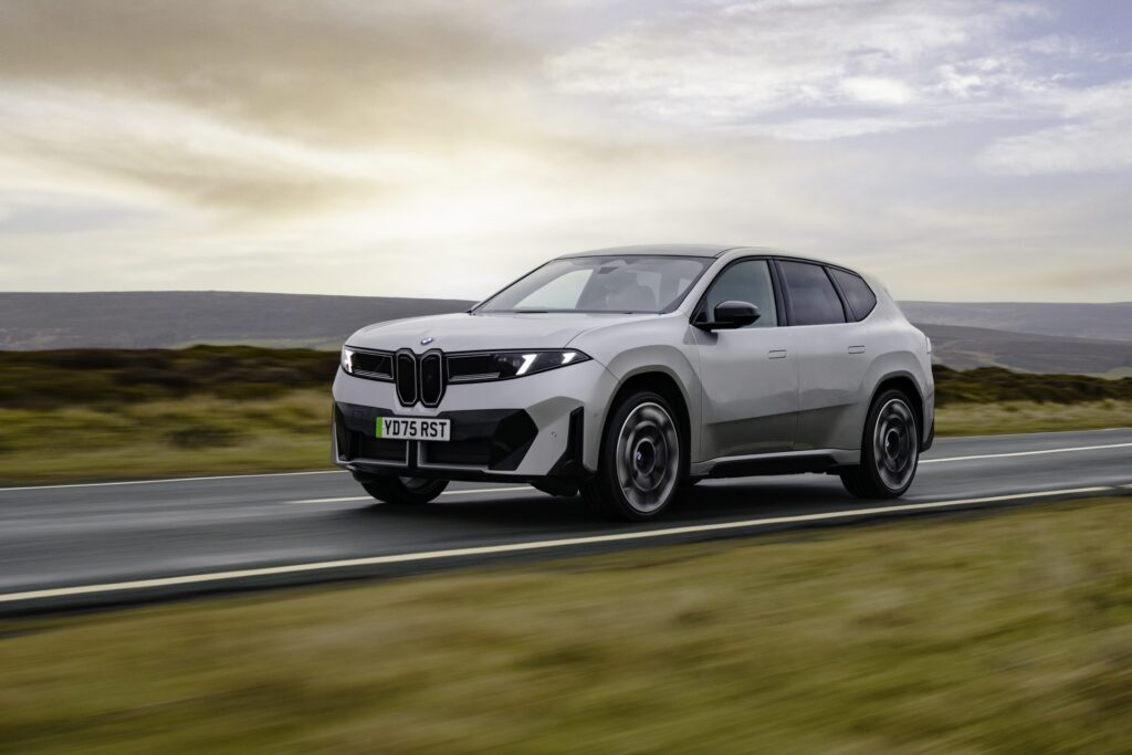 BMW iX3 electric SUV driving on a UK rural road — the modern EV pack a used buyer benchmarks against