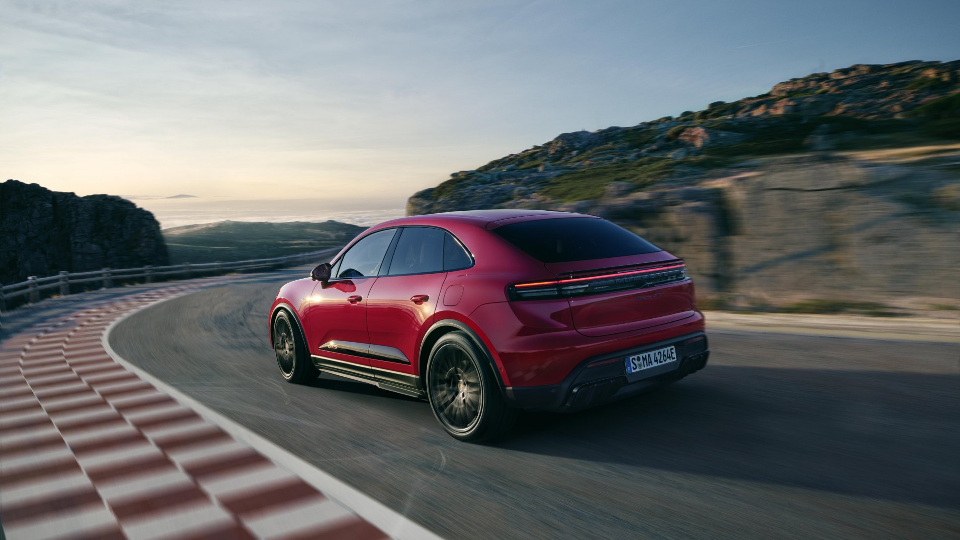 Porsche Macan EV insurance cost, red Macan Electric rear three-quarter on track