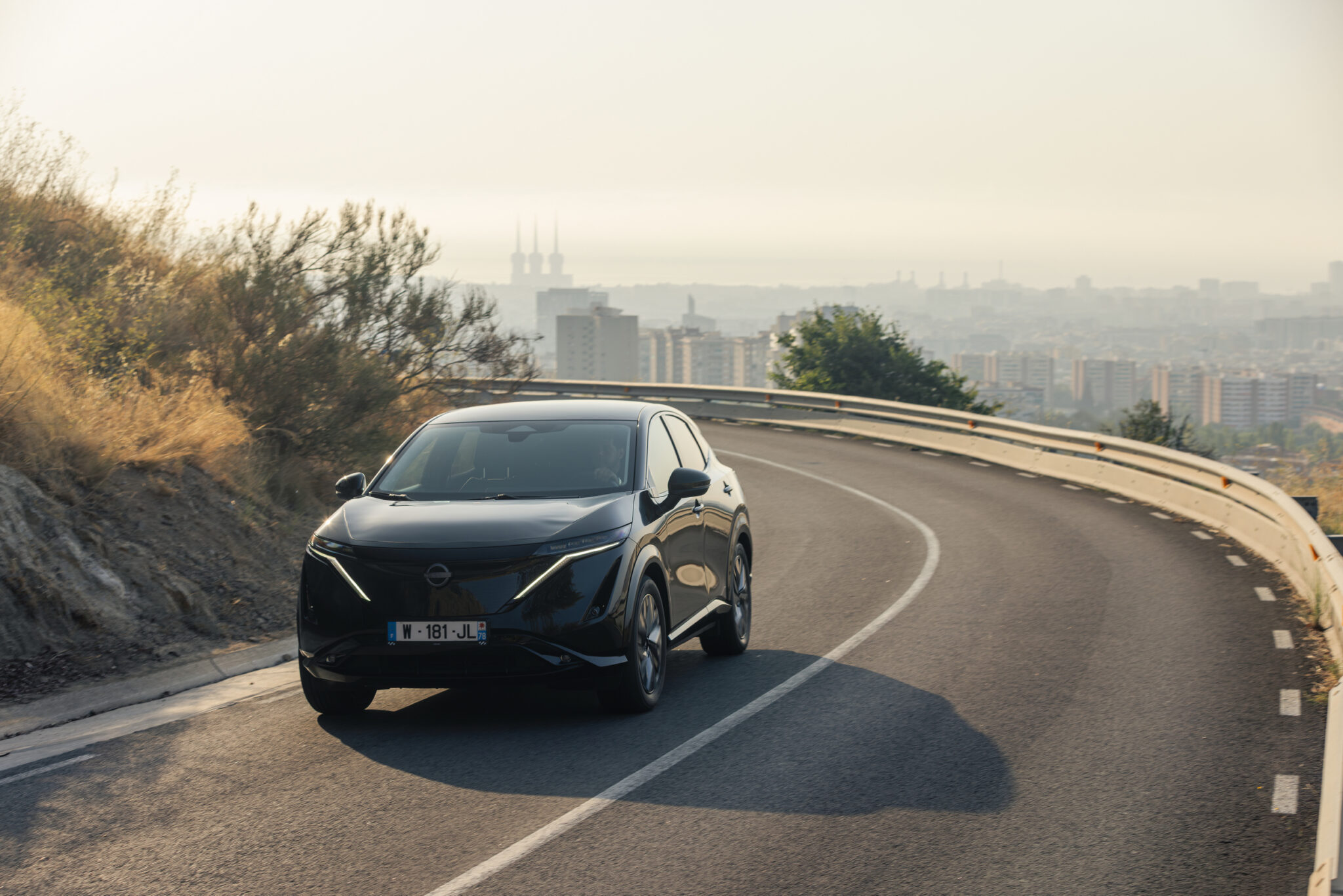 Electric SUV driving on an open road, a 1 to 3 year old EV facing a rising insurance renewal