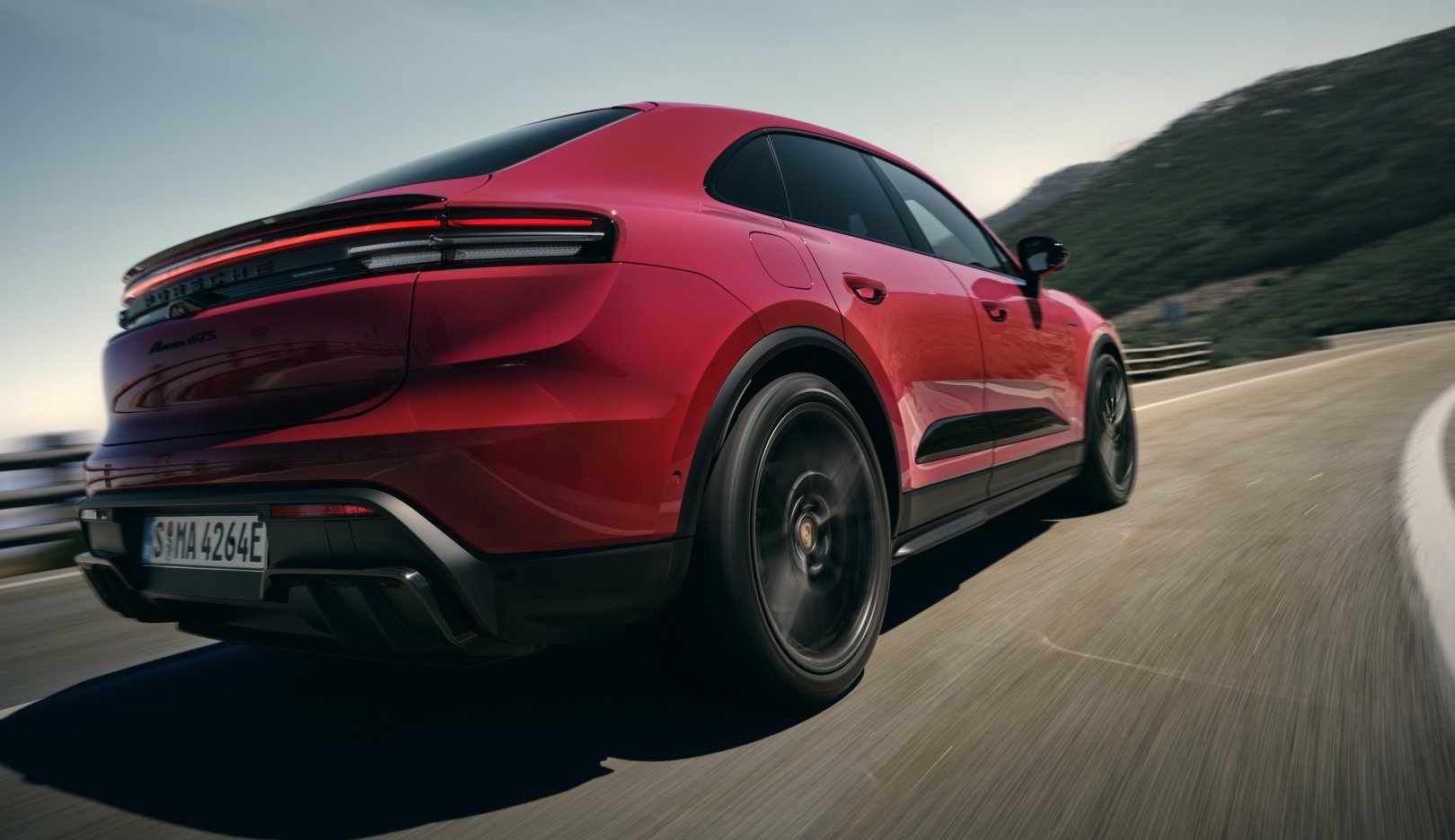 Porsche Macan EV insurance groups, red Macan Electric rear quarter at speed
