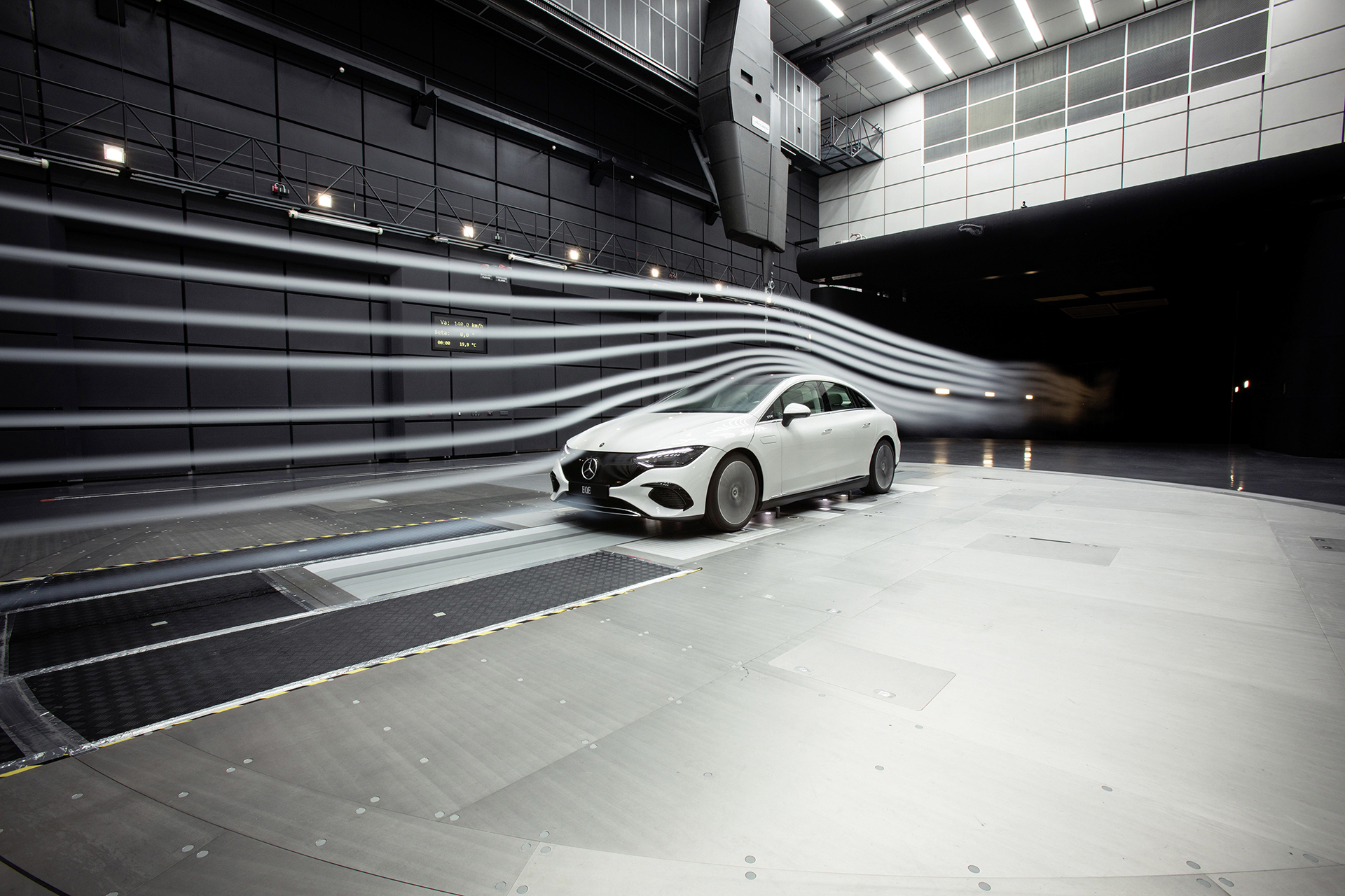 Mercedes EQE saloon in a wind tunnel showing airflow streamlines over the low-drag body