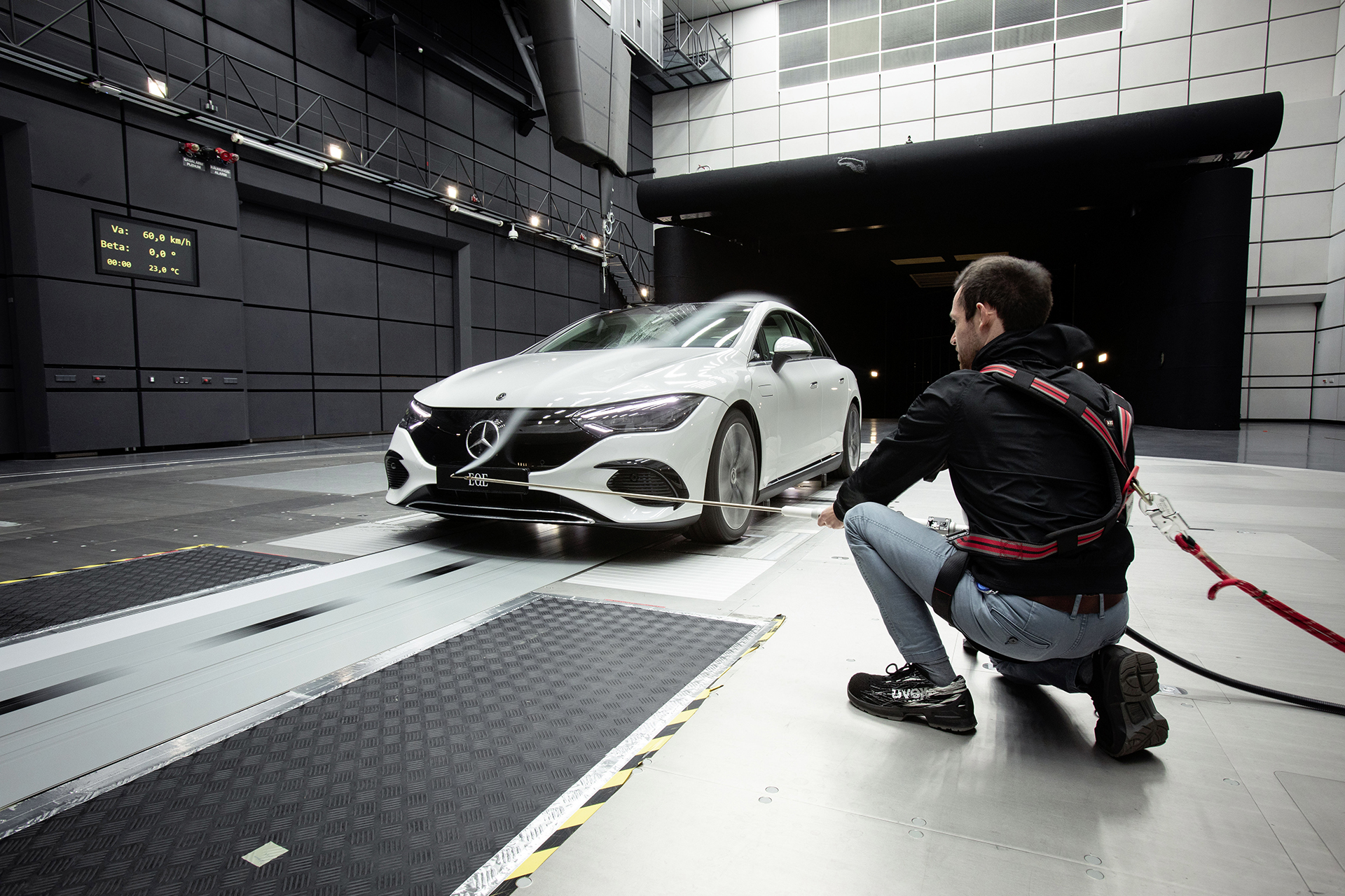 Mercedes EQE saloon in the Mercedes-Benz wind tunnel with a technician checking airflow