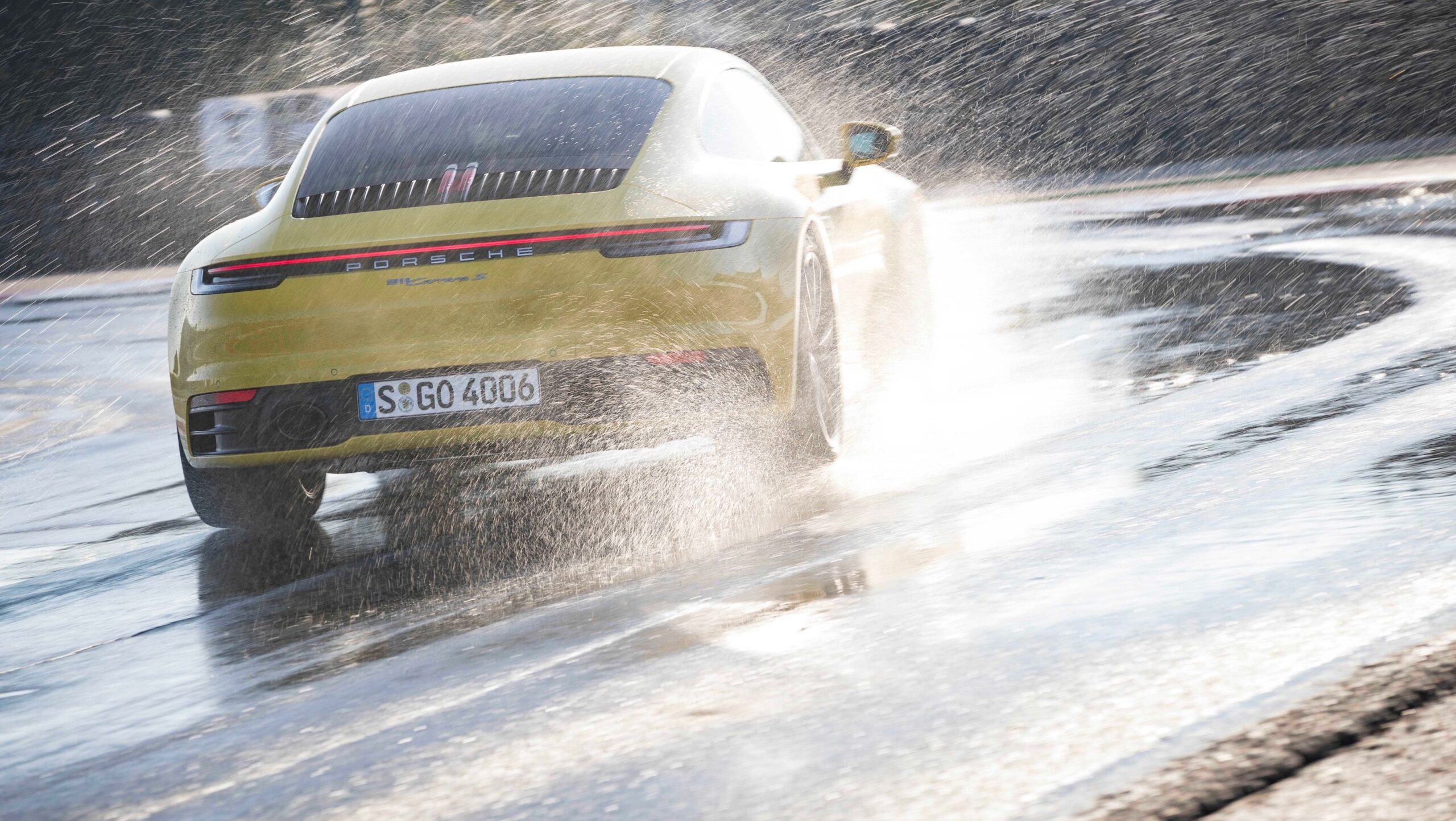 Porsche 911 992 Carrera rear three-quarter on a wet road, used buyer's guide