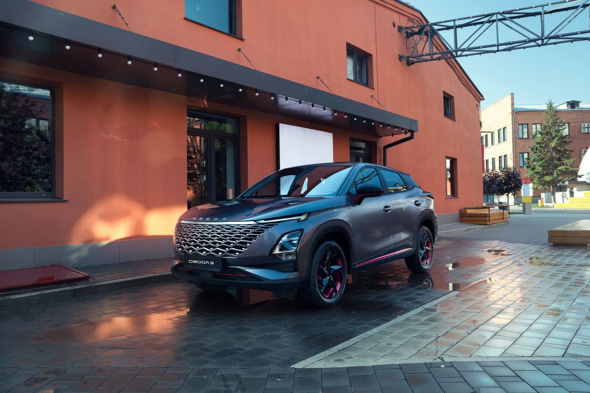 Omoda 5 PCP SUV in profile parked beside an industrial building