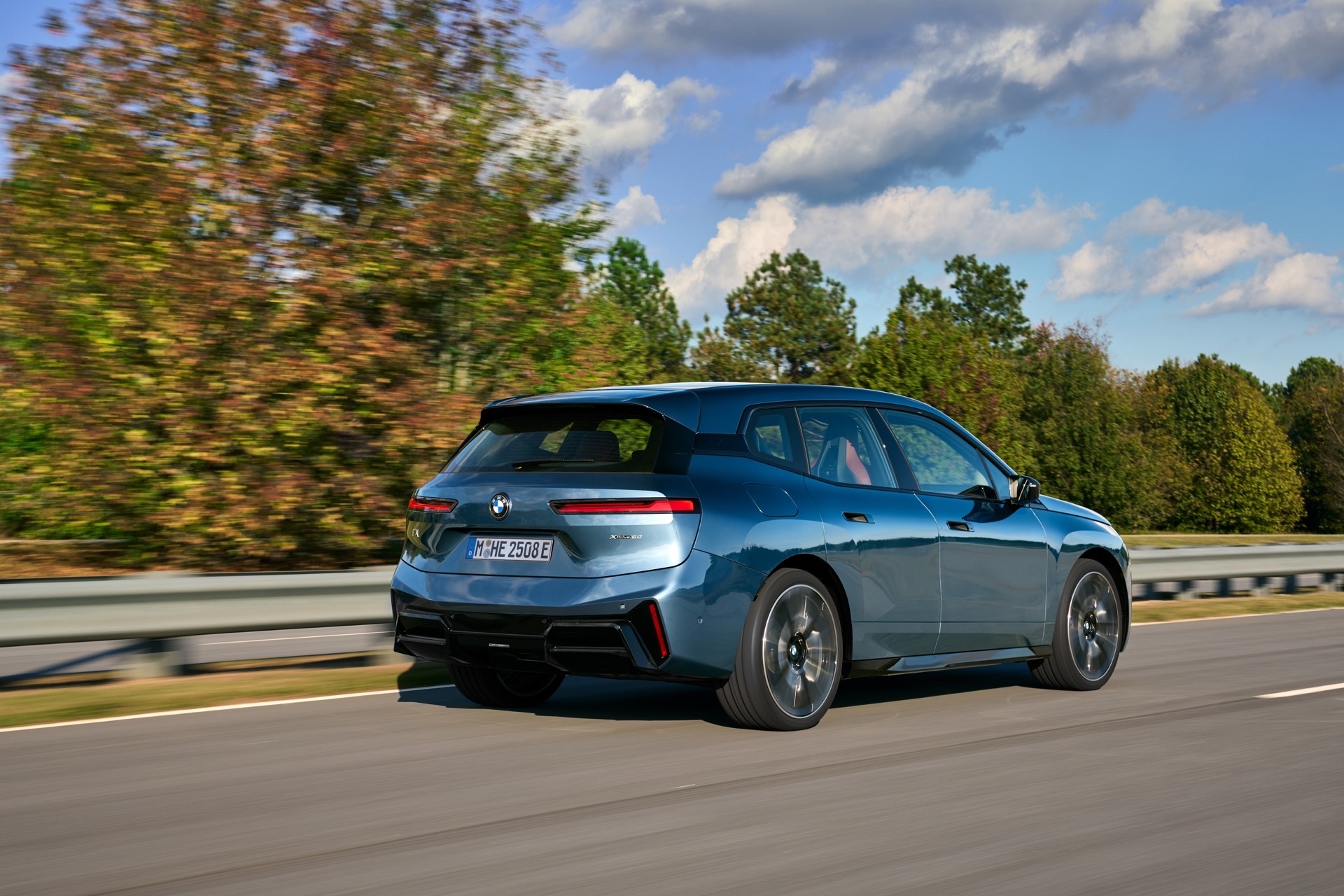 BMW iX rear three-quarter on the move, illustrating real-world range for the salary sacrifice buyer