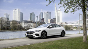Mercedes EQE saloon in white parked by a city riverside, the executive EV at the centre of salary sacrifice maths