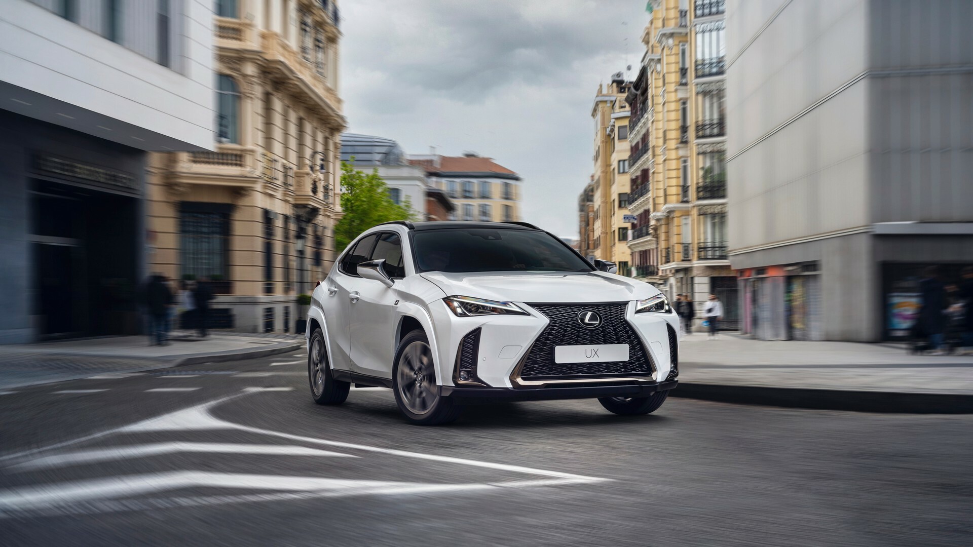 Lexus UX 300h hybrid driving through a city, safe-hands used premium crossover