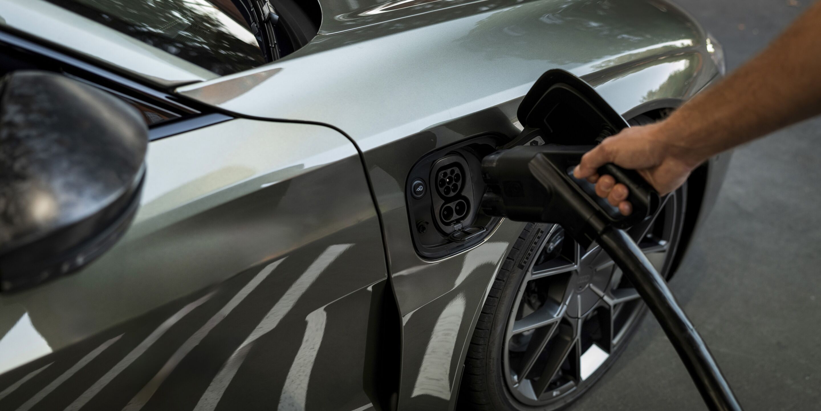 Charging cable plugged into an Audi EV, where the cost depends on home versus public charging