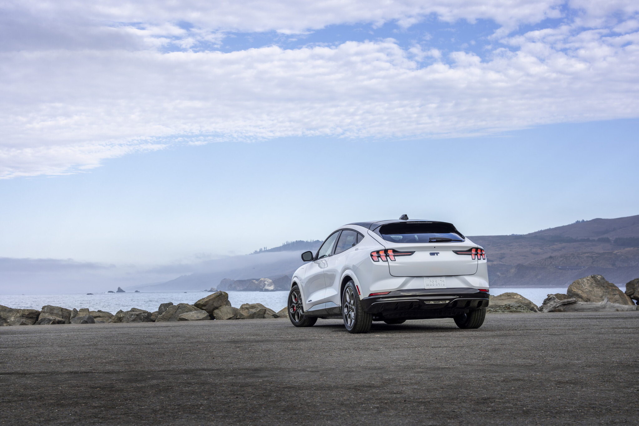 Ford Mustang Mach-E driving on a coastal road, sal-sac vs PCP