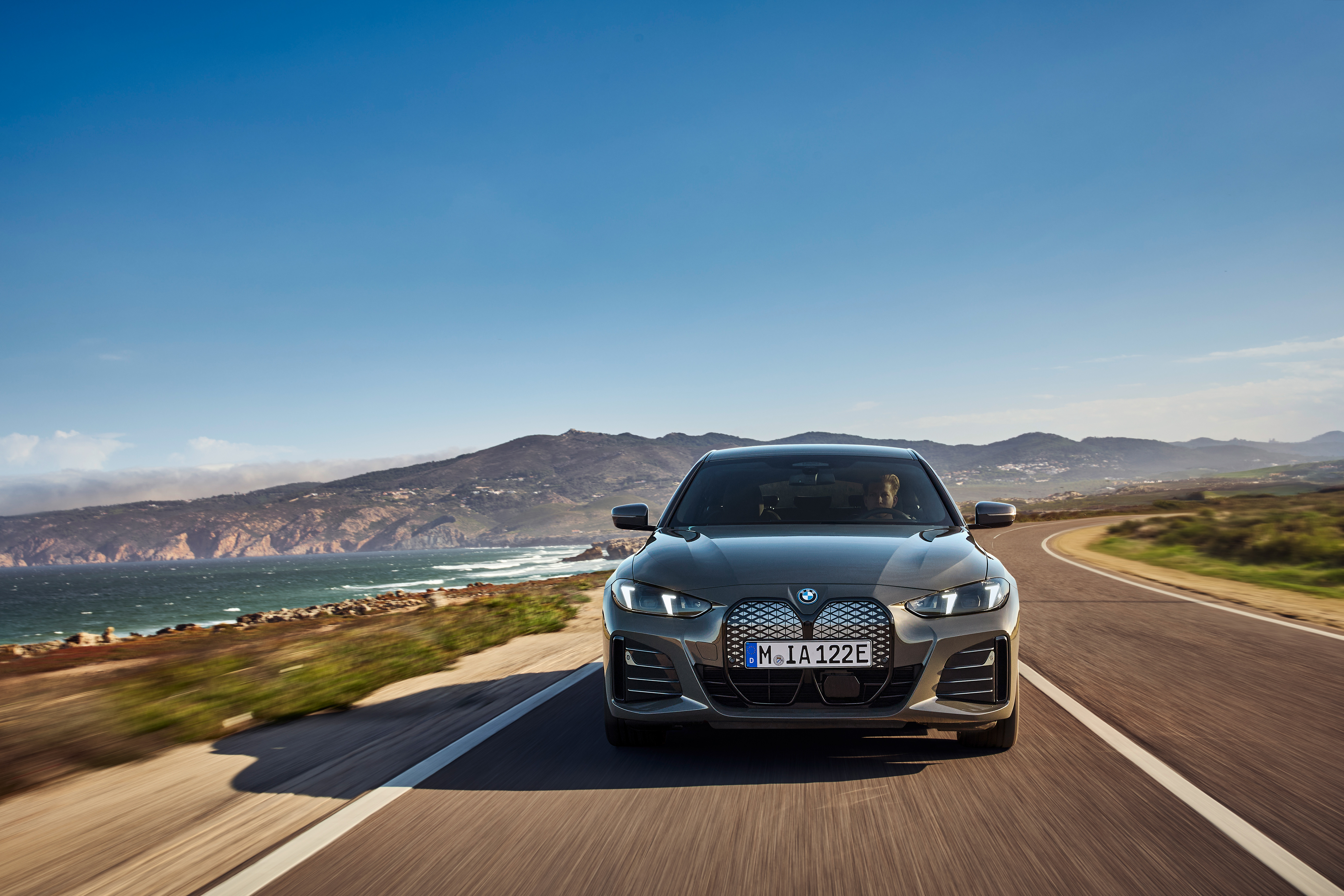 BMW i4 driving on a coastal road, front view