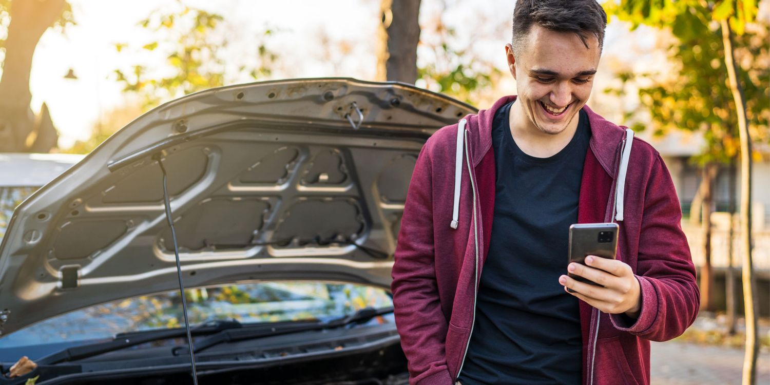 Driver checking a smartphone before borrowing a car, illustrating temporary car insurance in the UK