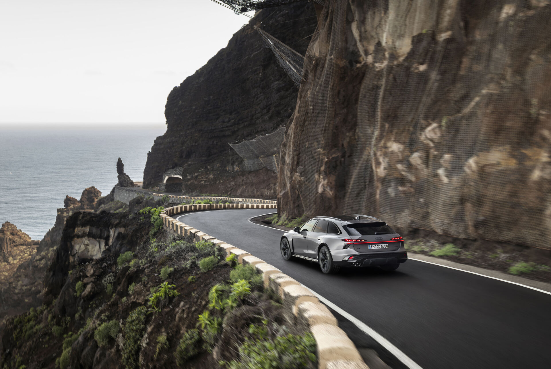 Audi A6 allroad driving on a winding coastal road